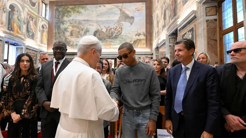 El papa saluda a Pharrell Williams en la víspera del macroconcierto en el Vaticano