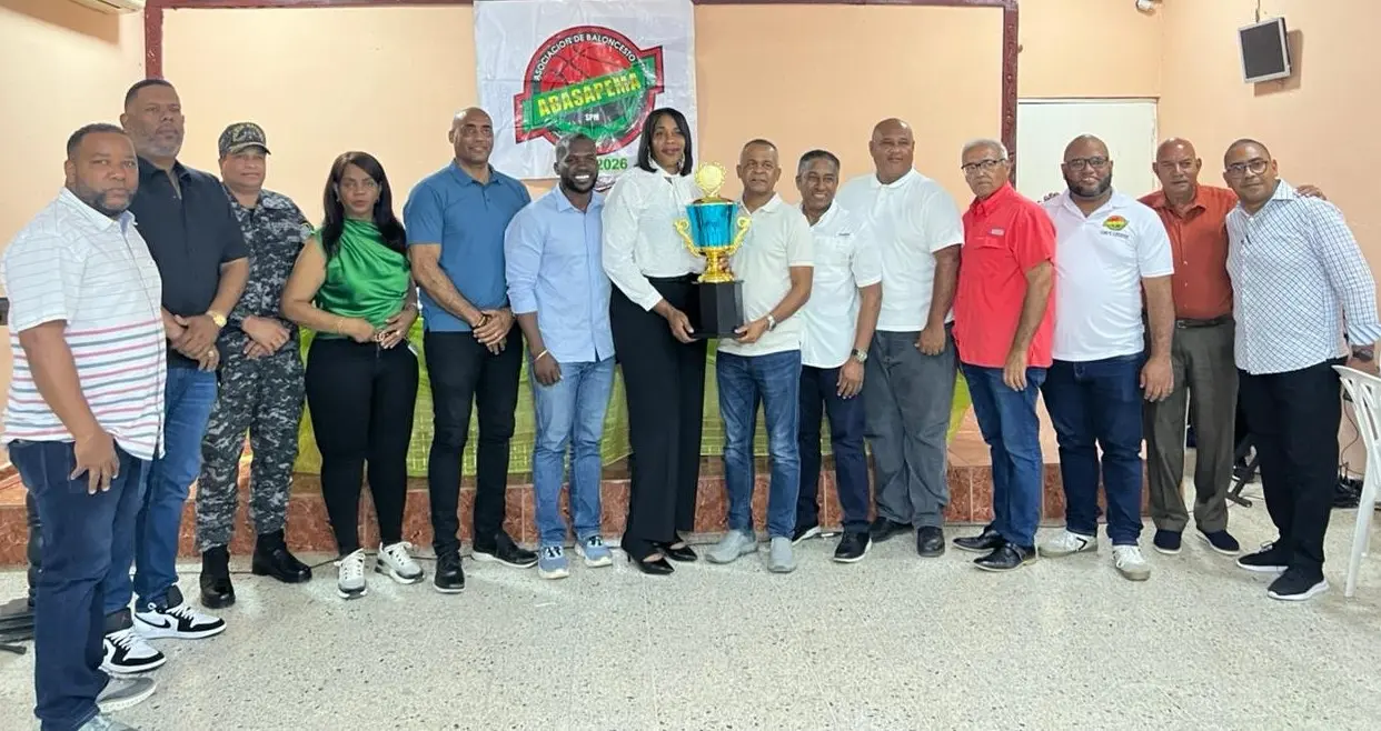 Pedro Vásquez, presidente del Comité Organizador TBS-SPM 2025, y Kathy Celestino, ejecutiva de Abasapema, con la Copa BanReservas junto a los miembros del CO.