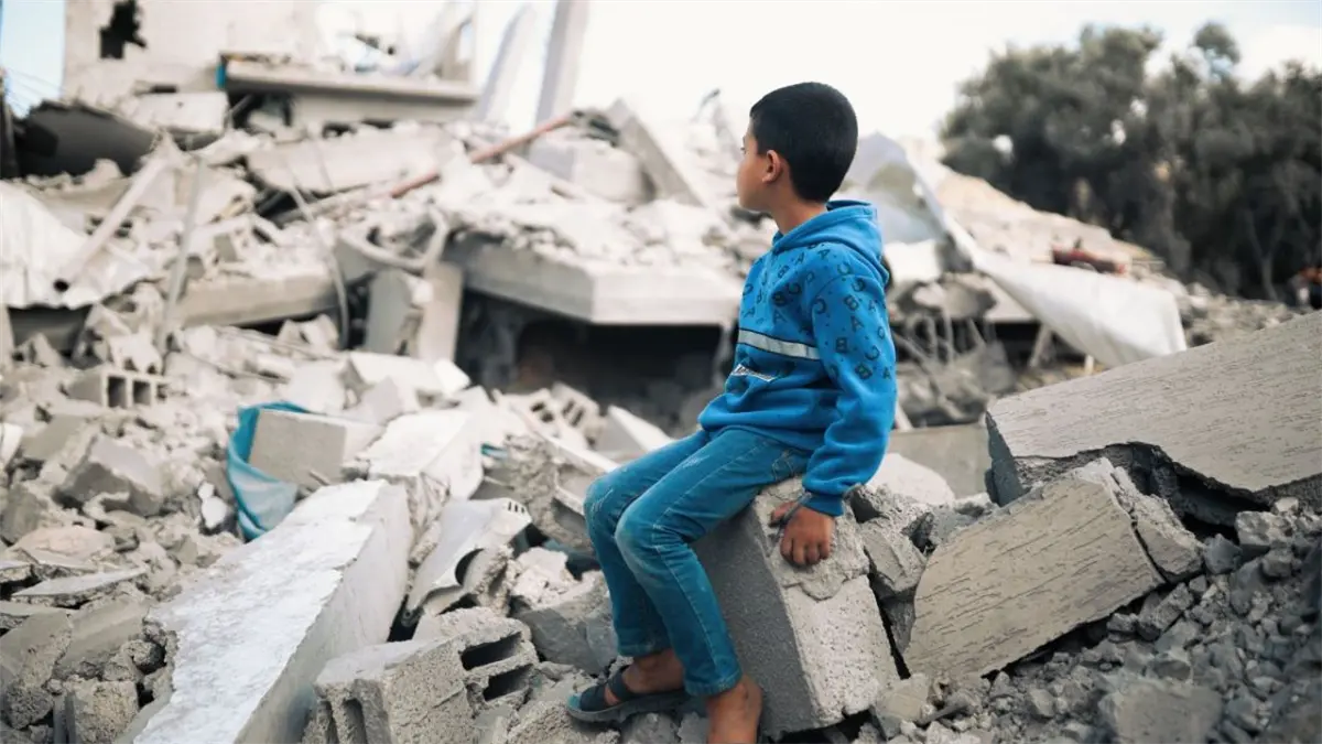 Niño frente a edificación destruida en Gaza