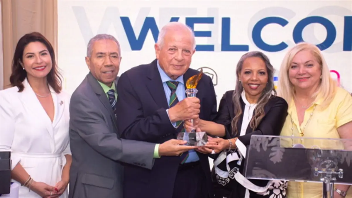 El periodista y exalcalde de Miami, Don Tomás Regalado, mientras recibe La Antorcha de la Democracia de manos de sus colegas Rose Mary Santana y Jesús Rojas, acompañados por la Alcaldesa de Doral, Christi Fraga, Alina García, Supervisora de Elecciones del Condado de Miami Dade y otras autoridades.