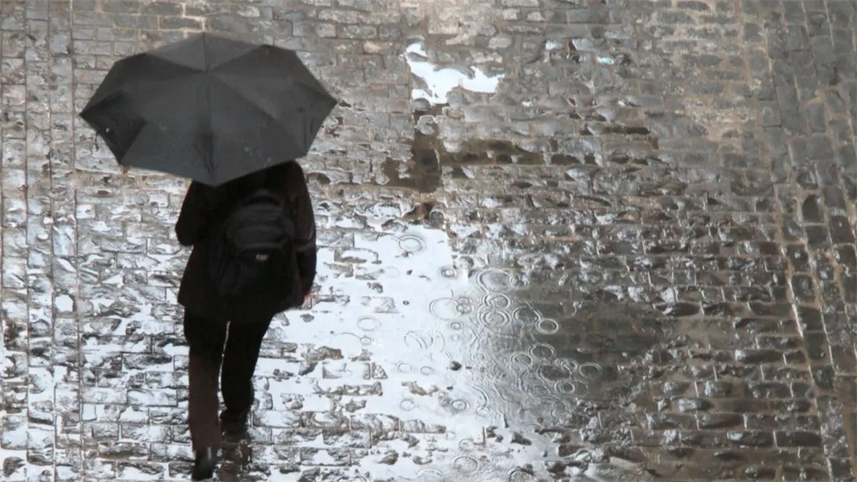 Mujer con sombrilla bajo la lluvia.