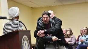 Un hombre roc&iacute;a con l&iacute;quido a congresista dem&oacute;crata Ilhan Omar en un m&iacute;tin en Mine&aacute;polis