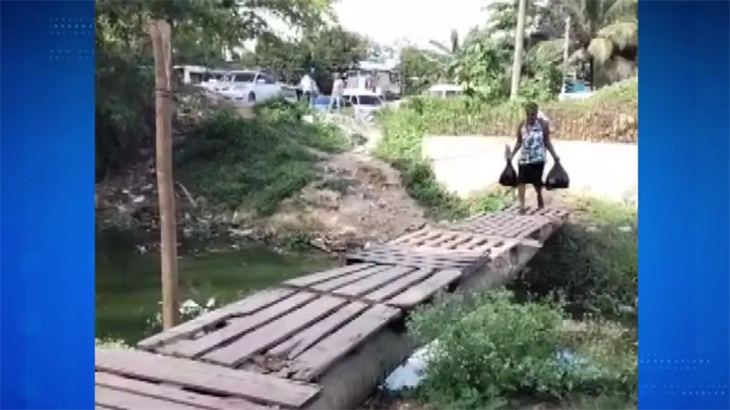 Improvisan puente con ramas y tablas para cruzar una ca&ntilde;ada