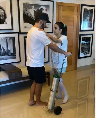 Aún con oxígeno puesto Yeri Peguero da sus primeros pasos de la mano de Manny Cruz