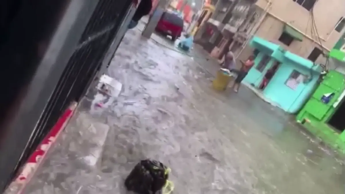 Arrojan basura a calle inundada por fuertes precipitaciones