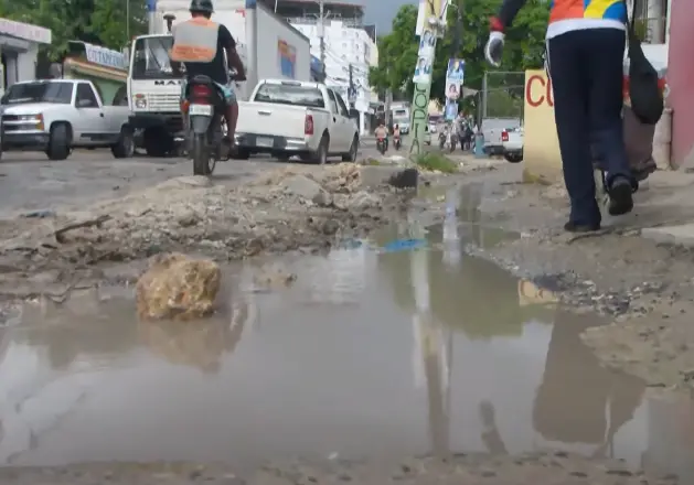 Entre hoyos y lodazales viven residentes del barrio Bayona en SDO