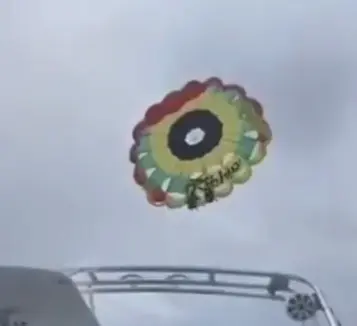 Momento en que dos personas caen al agua cuando practicaban paravelismo