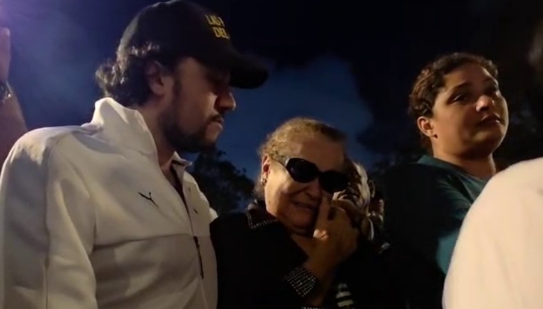 Grupo de personas reunidas al anochecer.