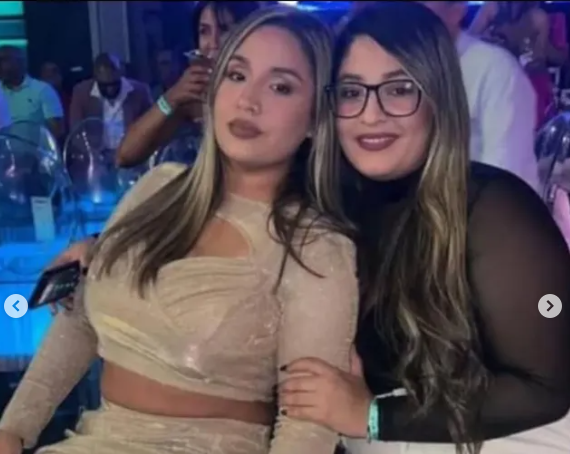 Dos amigas en un club nocturno sonríen juntas.