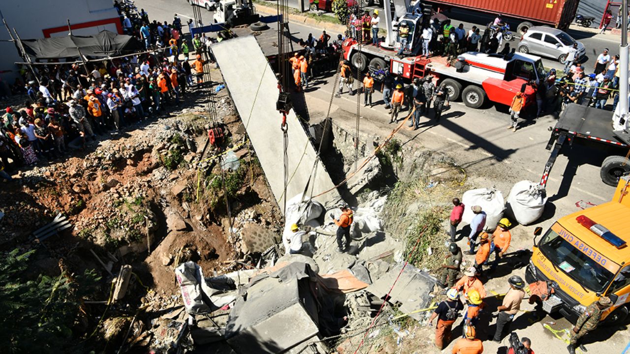 Rescate en zona de derrumbe con trabajadores y espectadores.