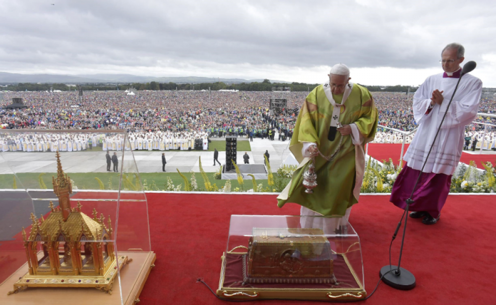 Ceremonia religiosa al aire libre con numerosos asistentes.