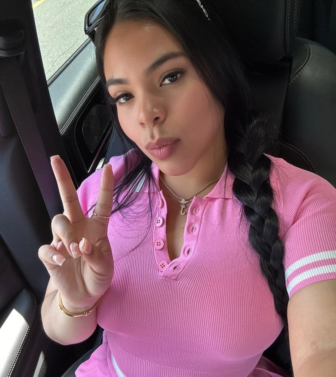 Persona vestida de rosa haciendo signo de paz.