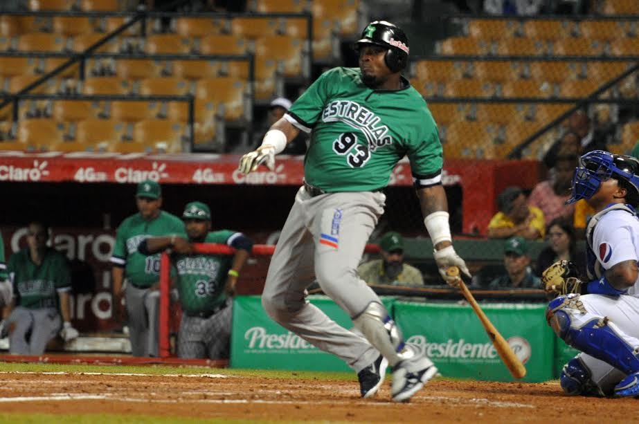 Jugador de béisbol haciendo un swing en estadio.