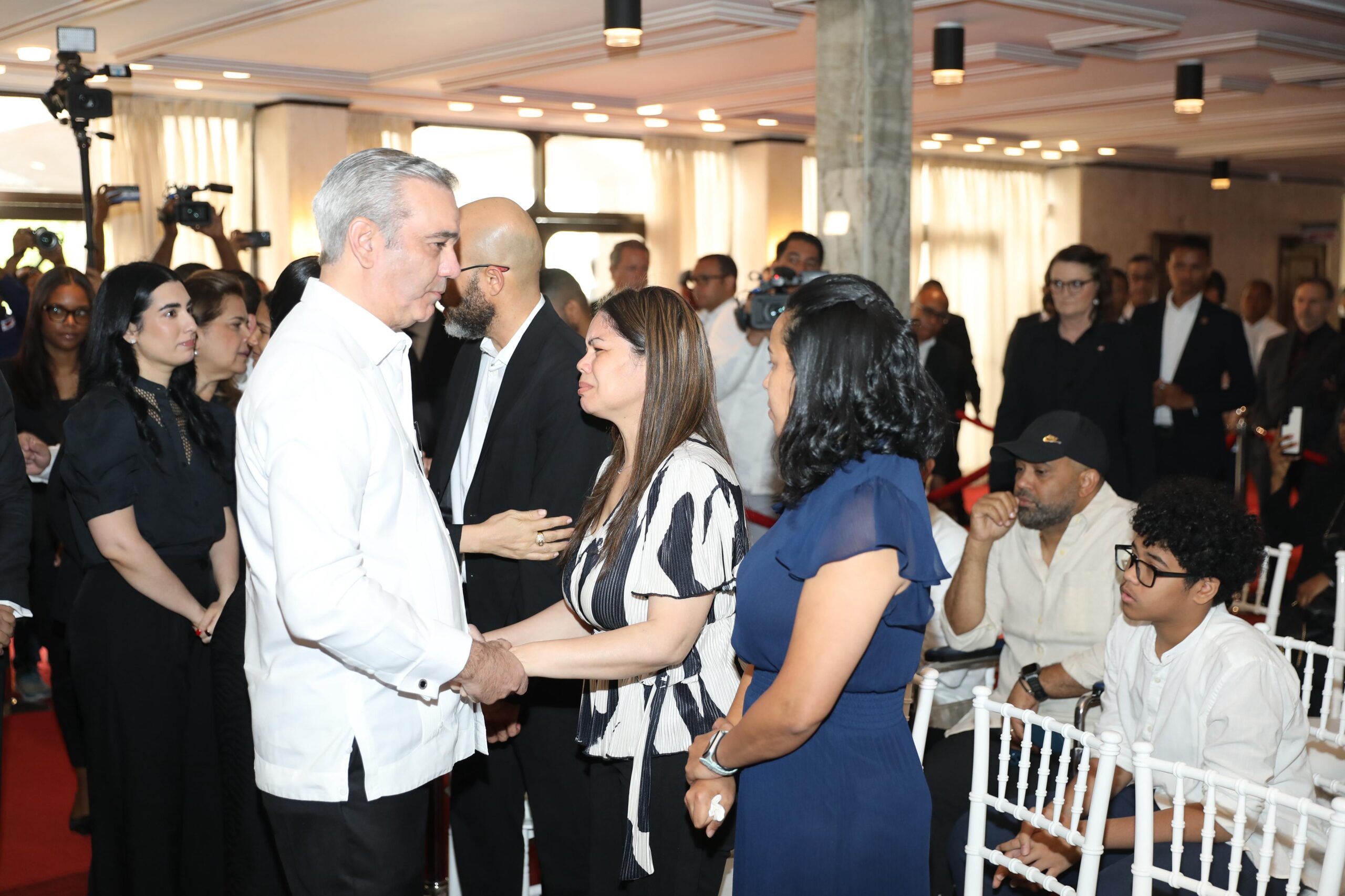 Evento con personas conversando en una sala formal.