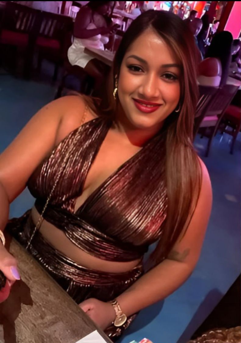 Mujer sonriente en restaurante con vestido brillante