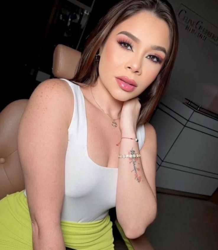 Mujer joven con vestido blanco y amarillo.