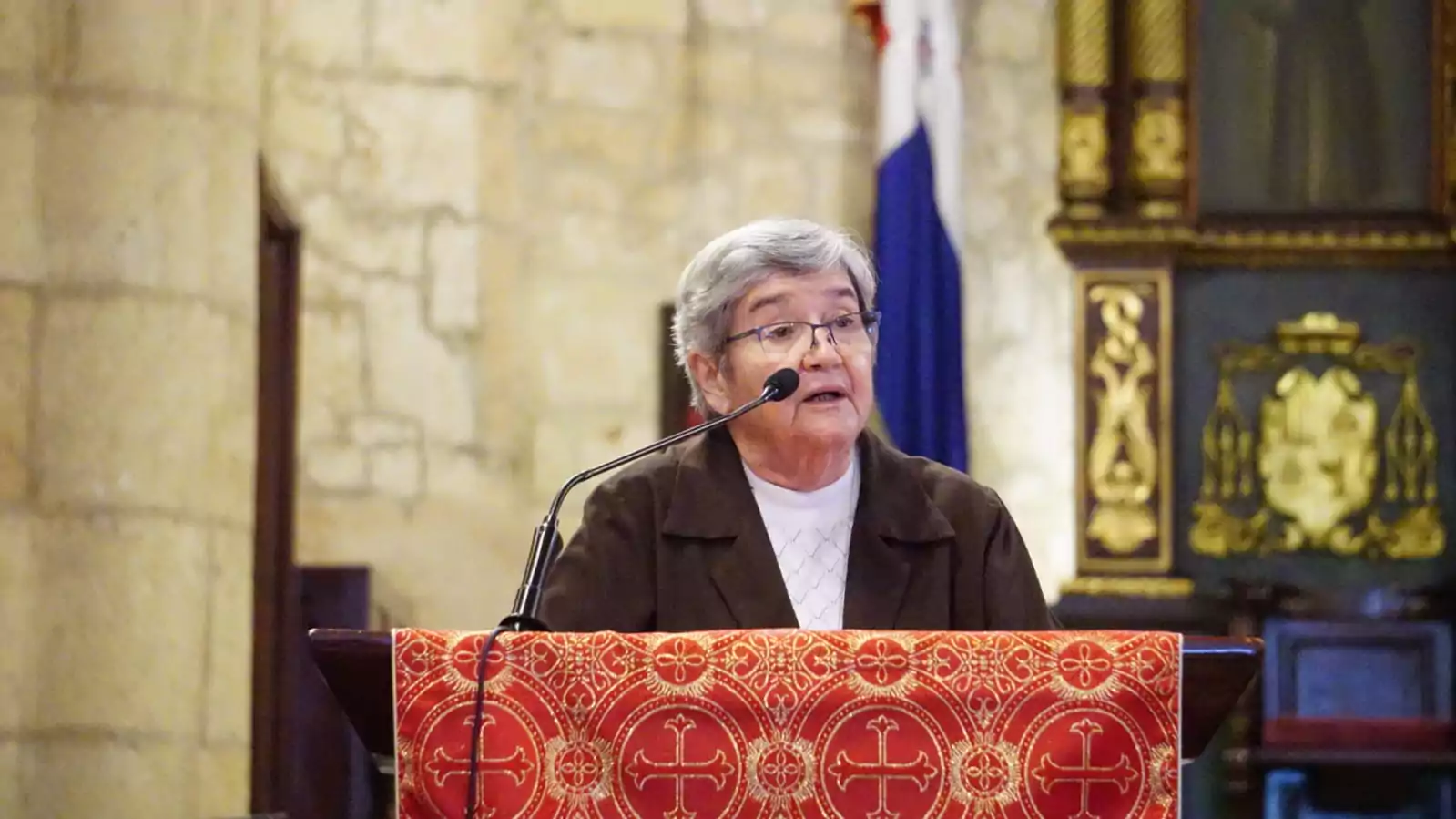 Persona hablando en atril de iglesia.
