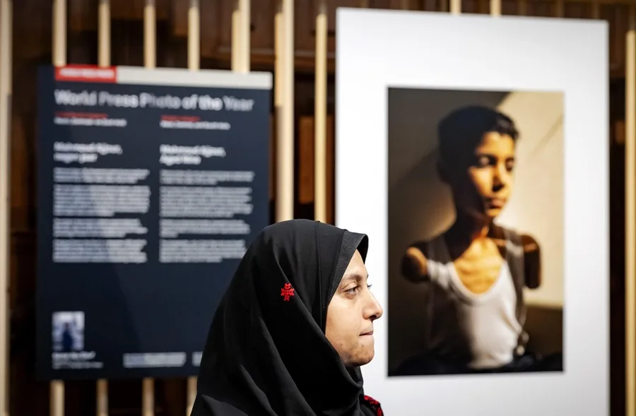 Mujer en exposición fotográfica sobre fondo borroso
