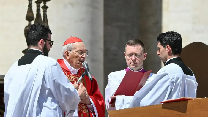 Cardenal en misa con tres sacerdotes asistentes.