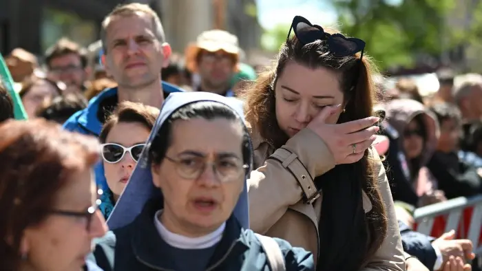 Multitud mirando solemnemente en una procesión religiosa