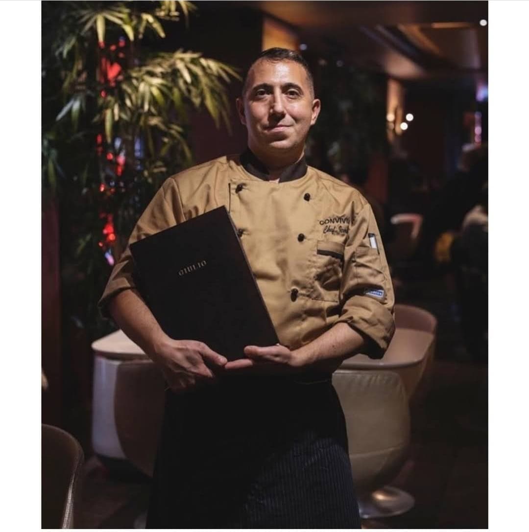 Cocinero sosteniendo menú en restaurante elegante