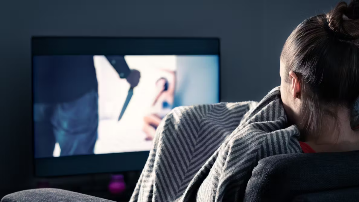 Persona viendo película de suspenso en televisión
