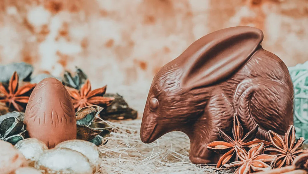 Conejo y huevo de chocolate en paja.