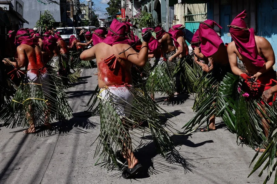 Personas con vestimenta tradicional bailan en la calle.