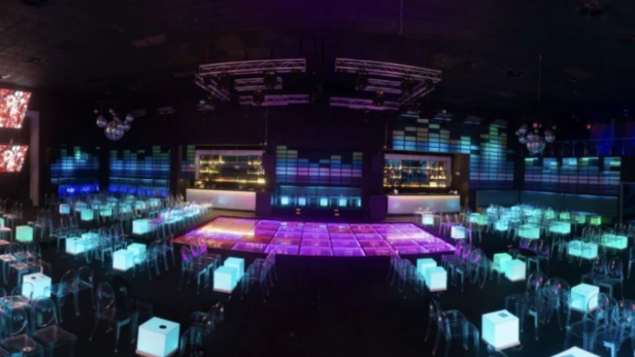 Discoteca moderna con luces brillantes y pista de baile.