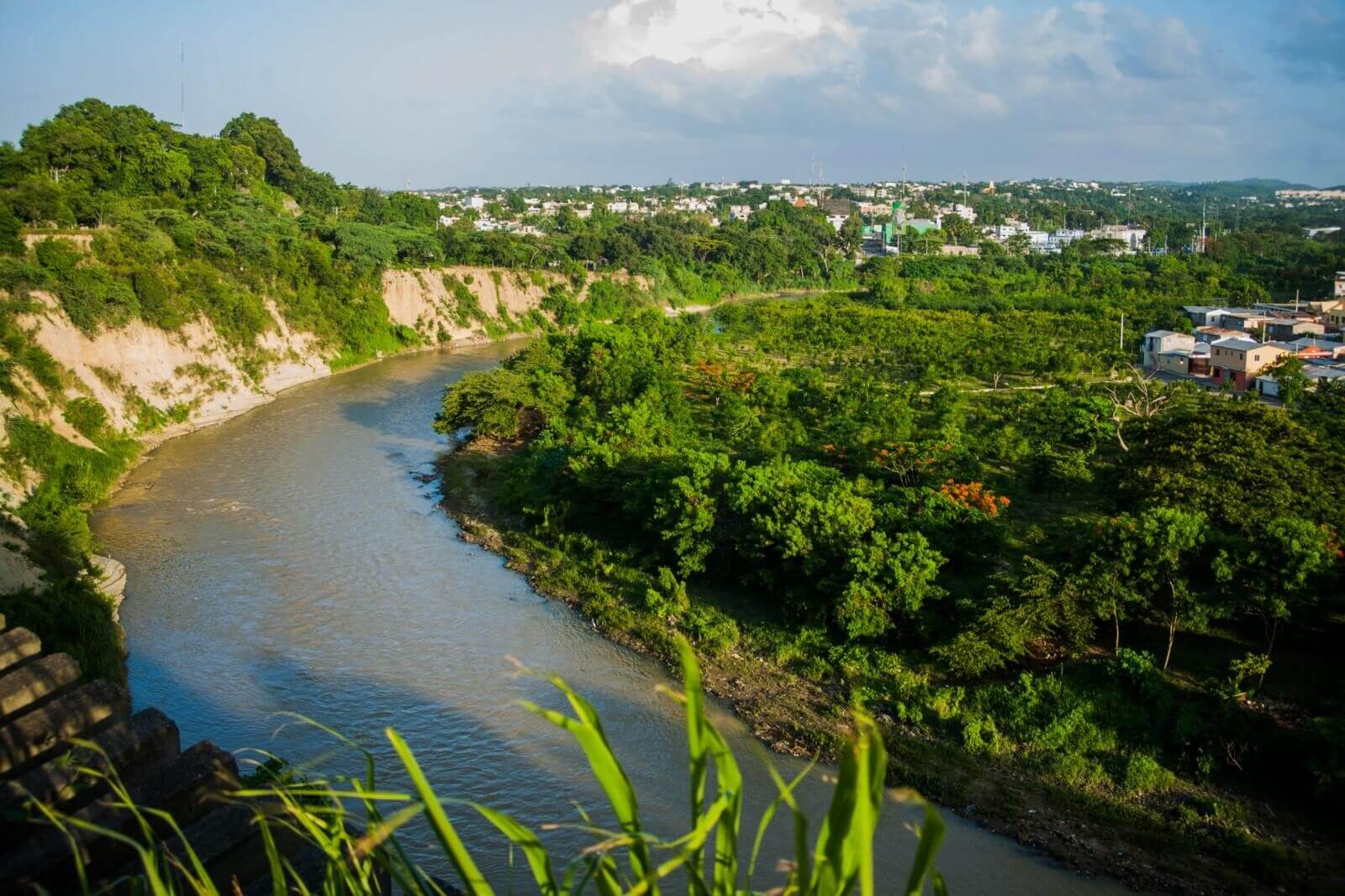 Río curvado entre paisaje verde y urbano