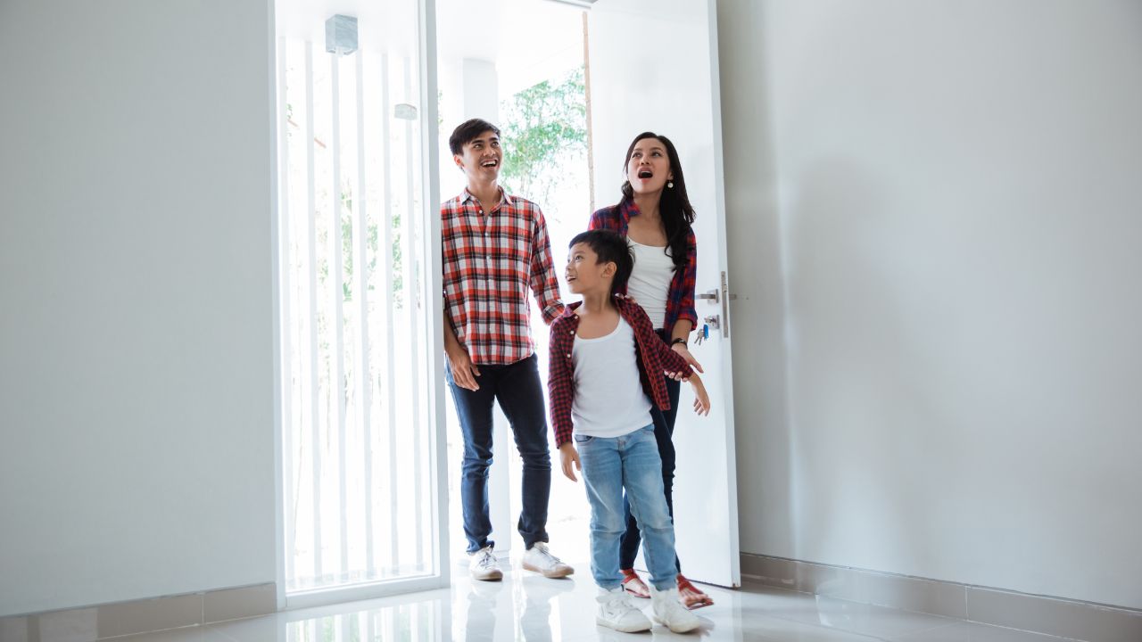 Familia feliz entrando a su nuevo hogar.