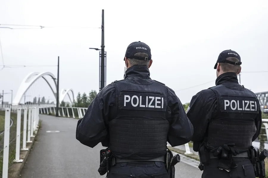 Dos policías patrullando un puente moderno.