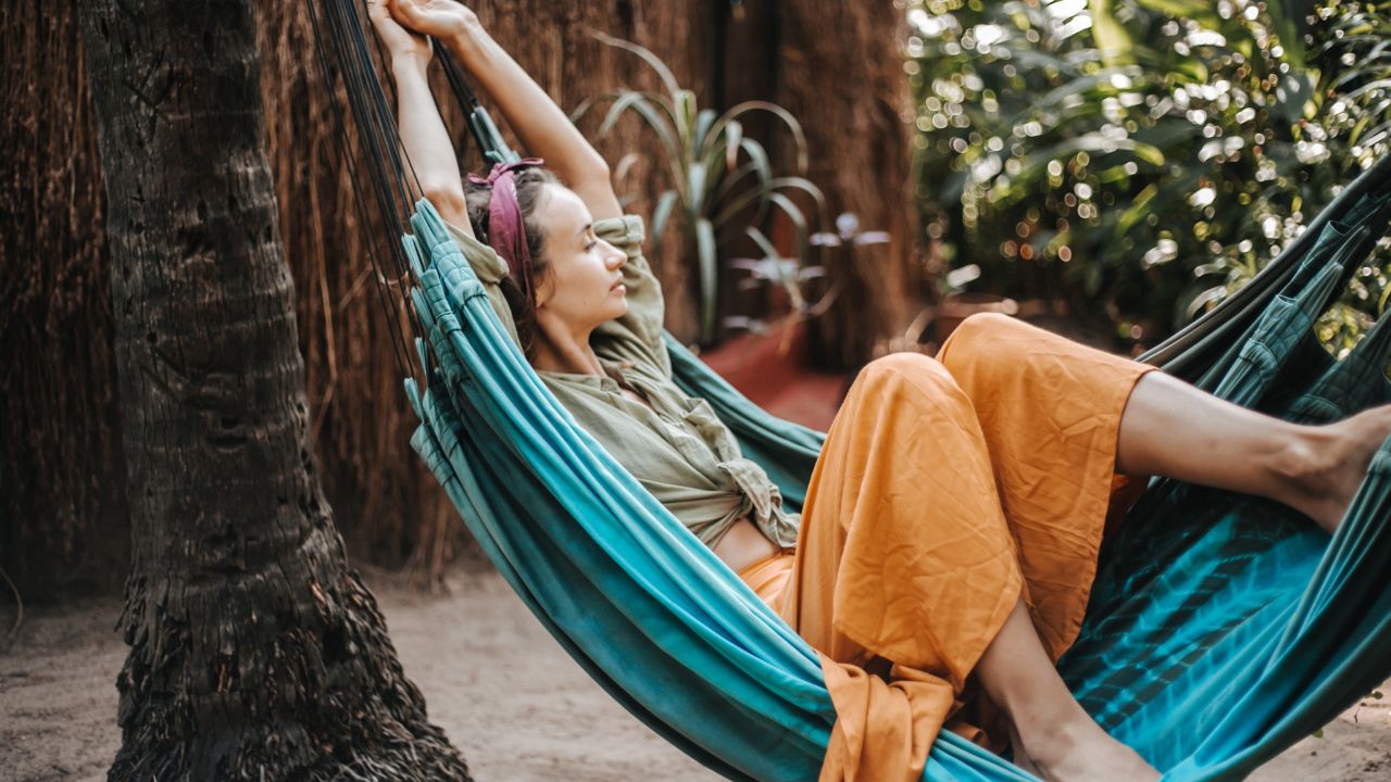 Persona relajándose en hamaca al aire libre