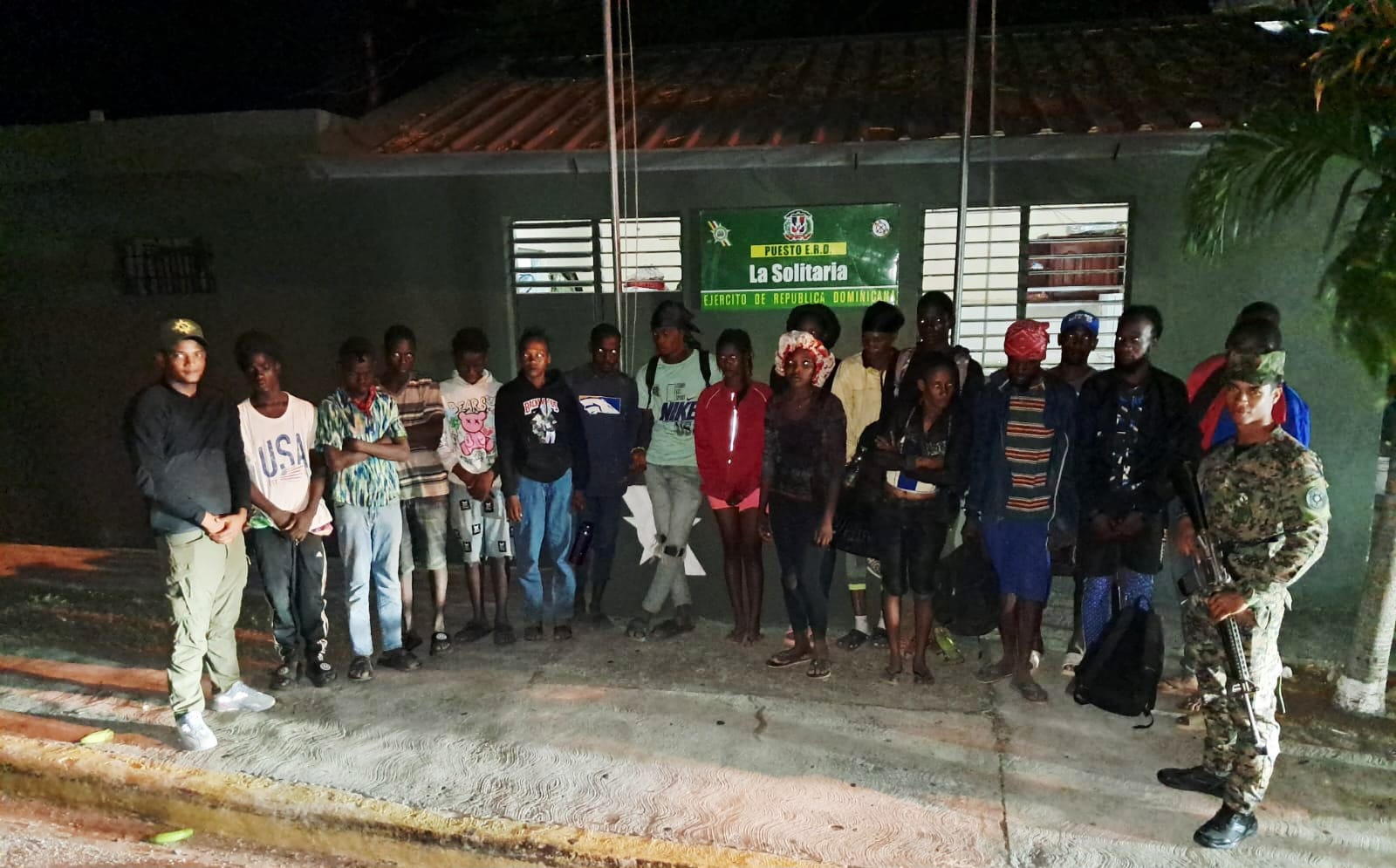Grupo de personas frente a un edificio militar