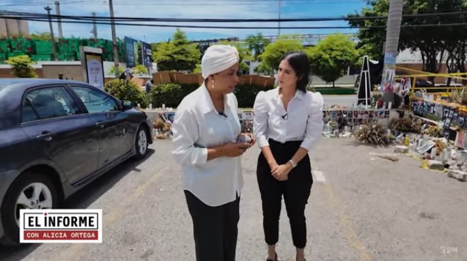 Dos mujeres conversando en un estacionamiento.