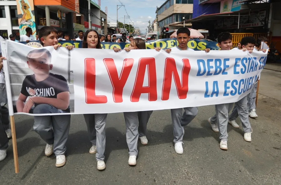 Estudiantes marchan con pancarta en protesta escolar
