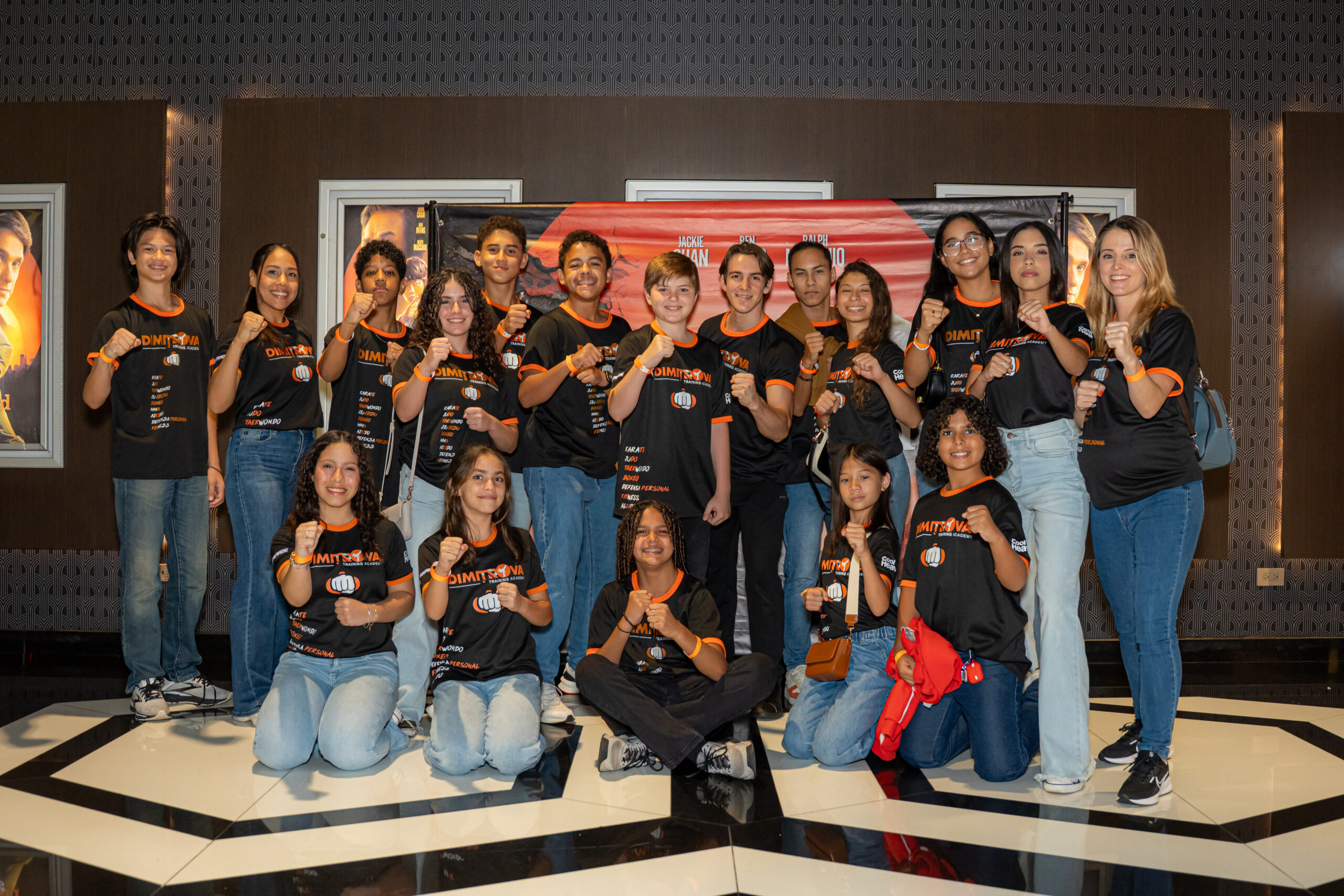 Grupo de personas con camisetas negras y naranjas.