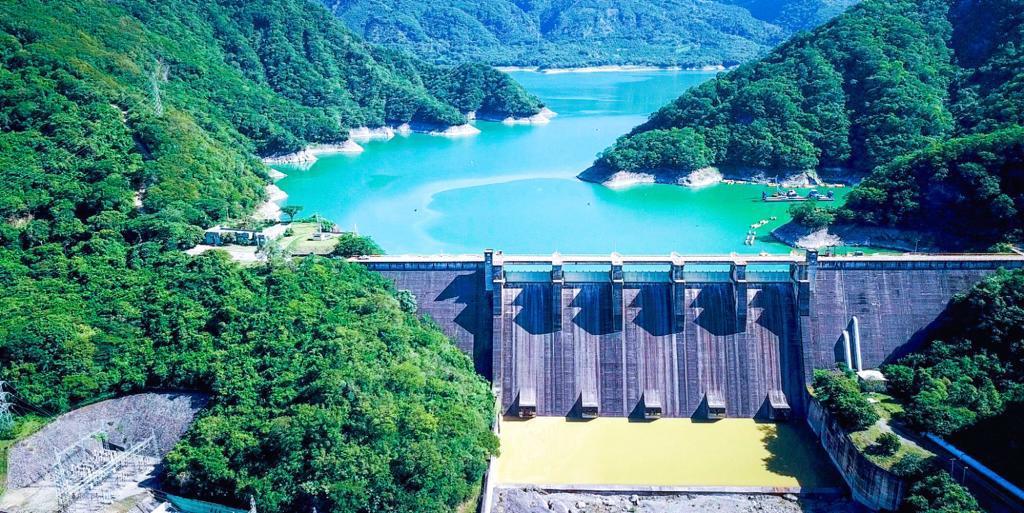 Presa en paisaje montañoso con lago azul.