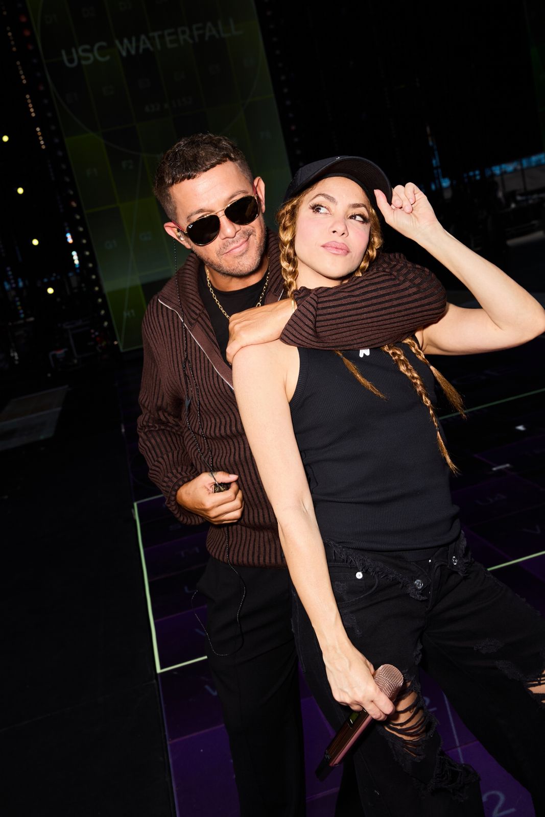 Dos personas con micrófono en escenario.