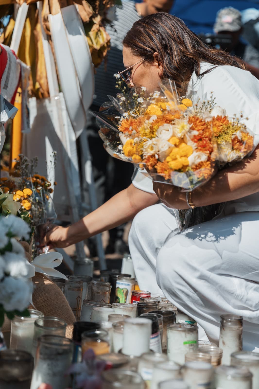Persona colocando flores en altar con velas
