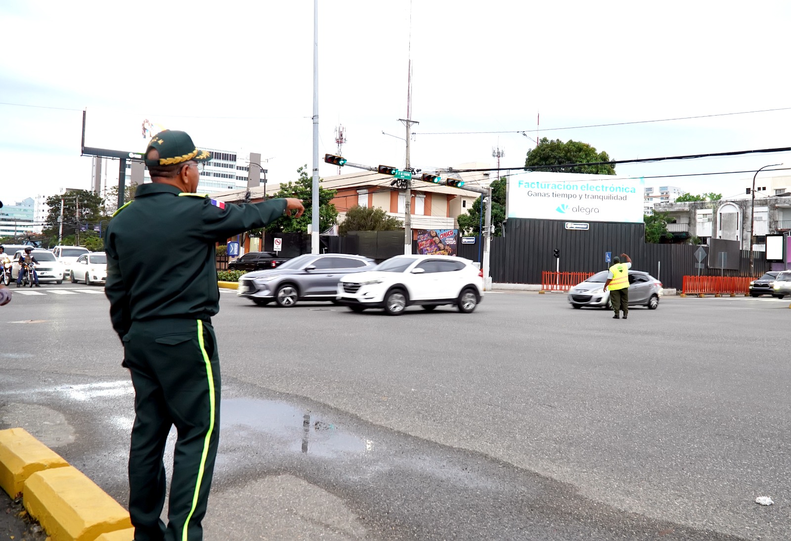 Policías dirigen tráfico en intersección urbana.