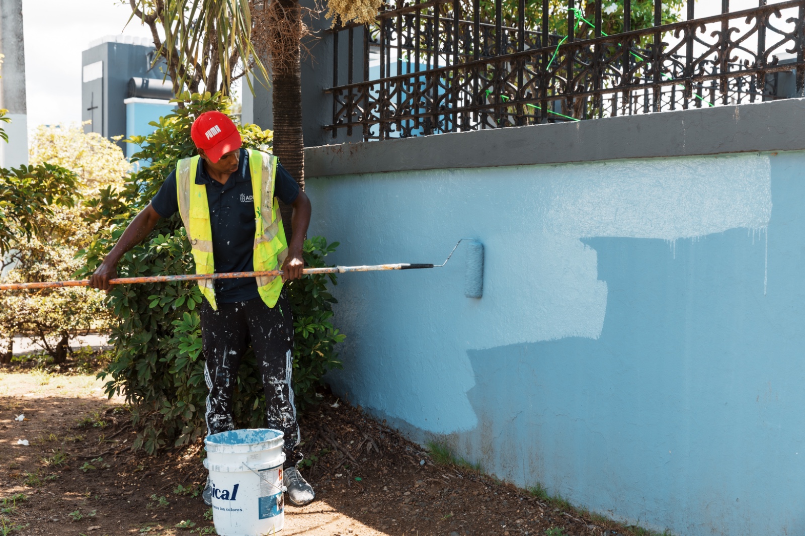 Hombre pintando pared azul con rodillo