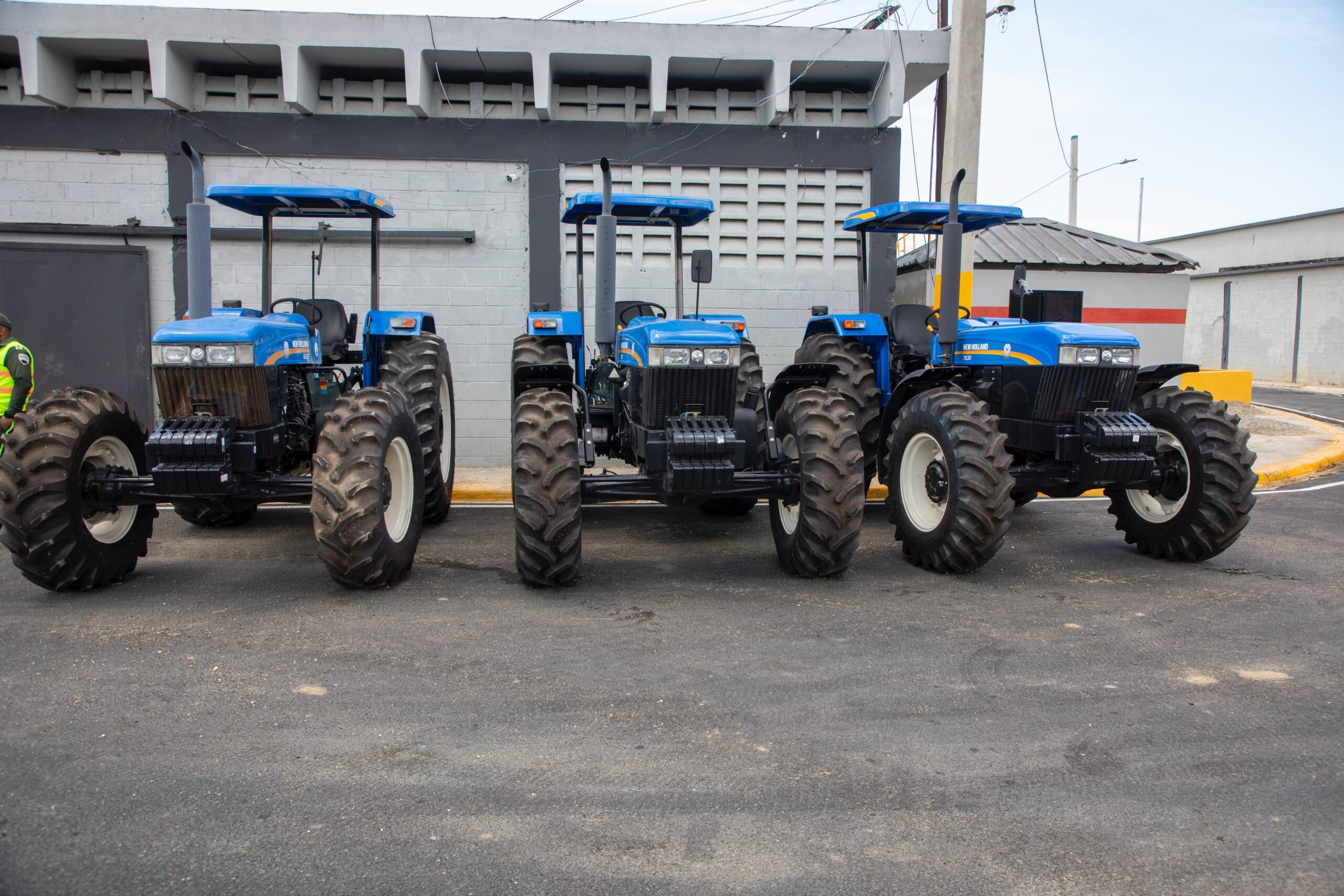 Tres tractores azules estacionados en fila