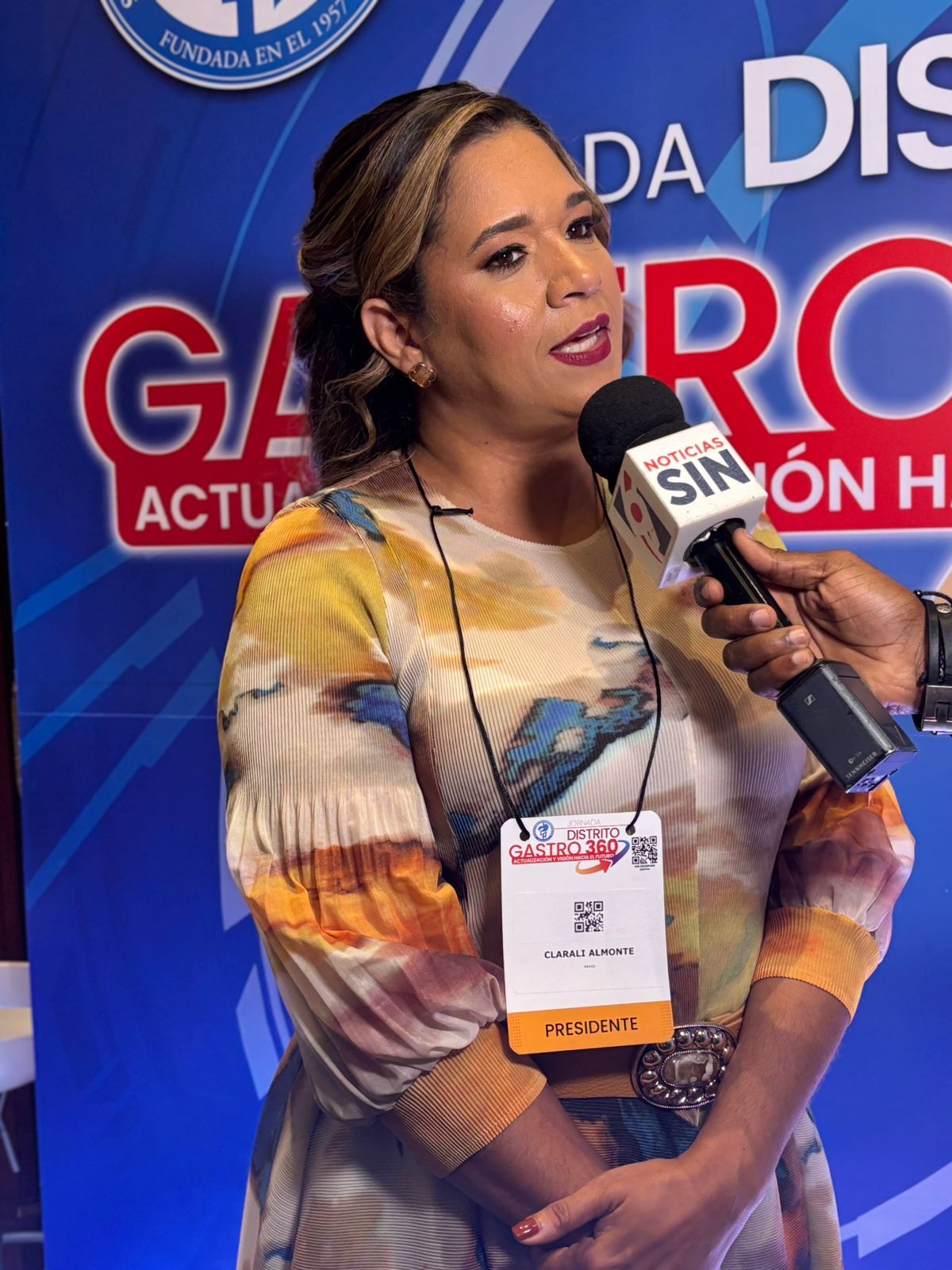 Mujer siendo entrevistada en evento.