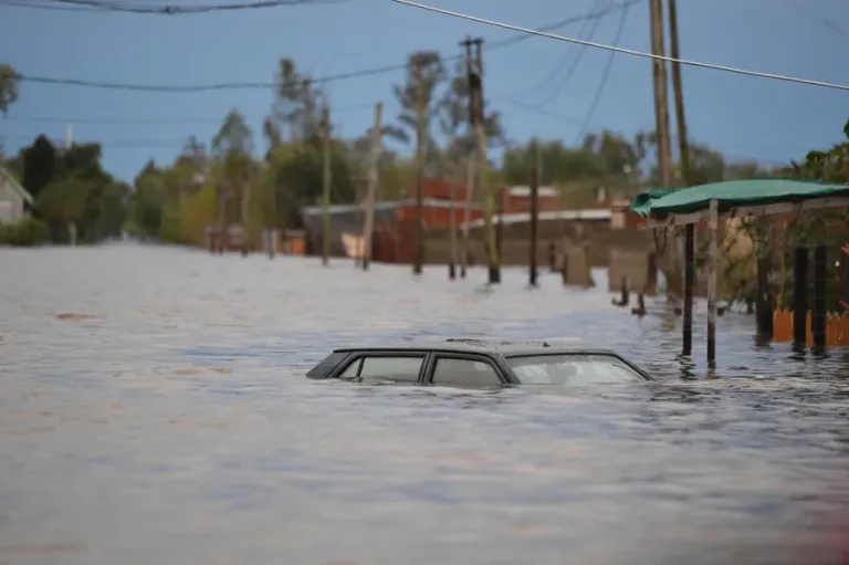 Coche sumergido en una calle inundada.