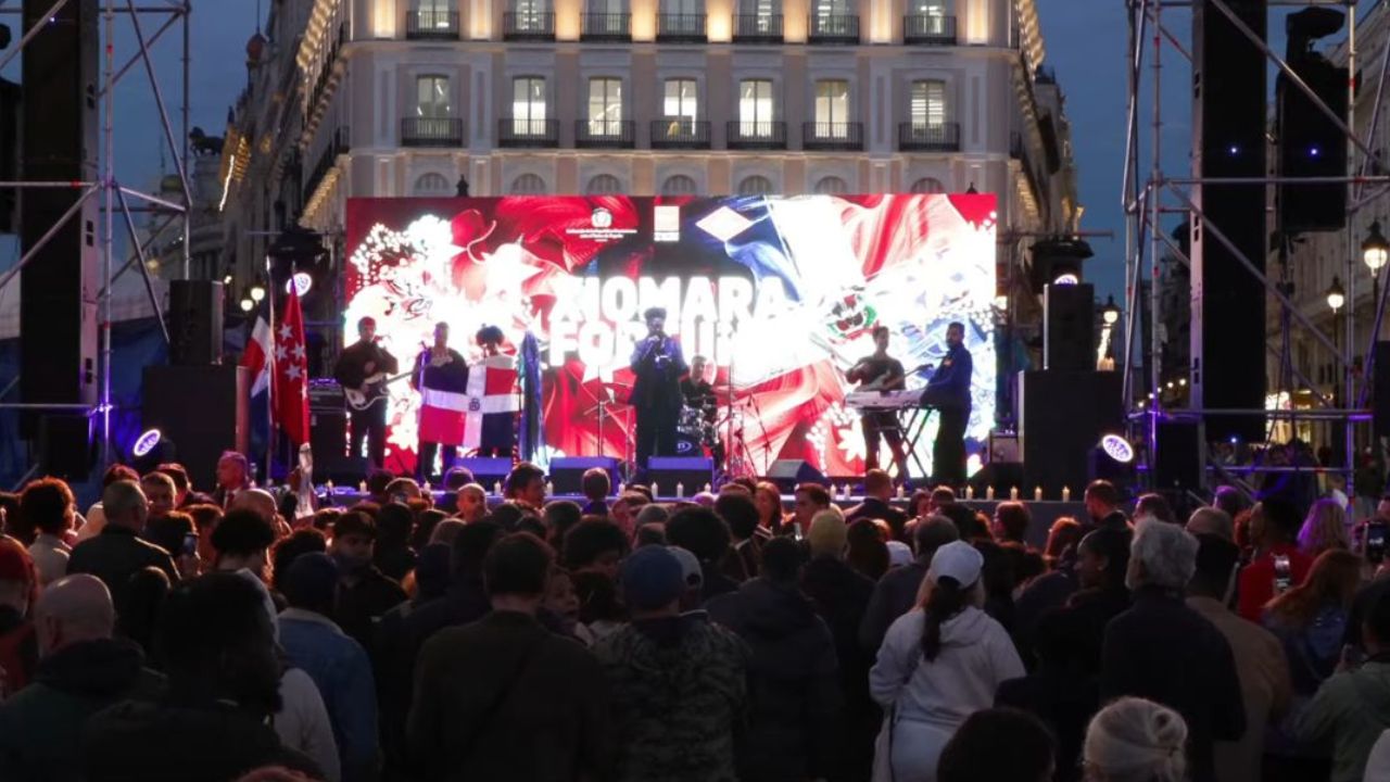 Concierto al aire libre en plaza pública concurrida.