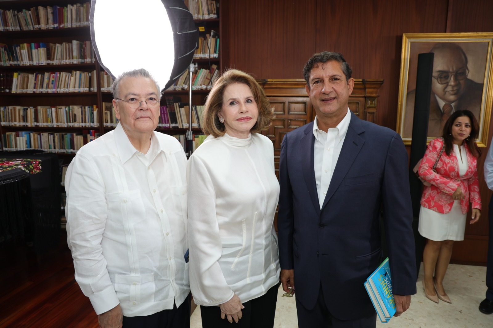 Personas posando en biblioteca con libros.