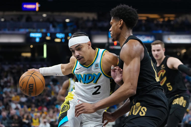 Jugadores de baloncesto disputando el balón en cancha.