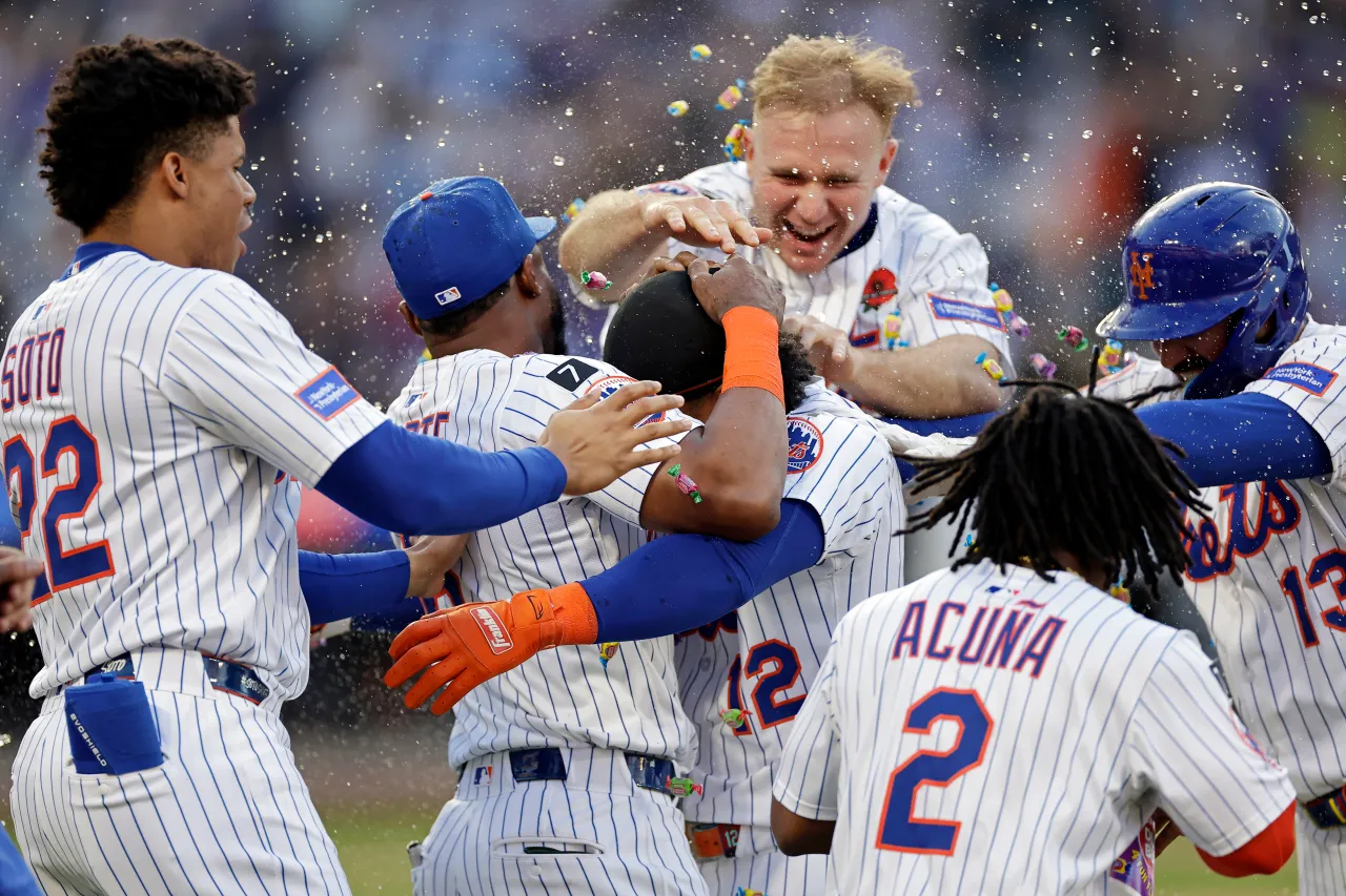 Jugadores de béisbol celebrando en uniforme de rayas.