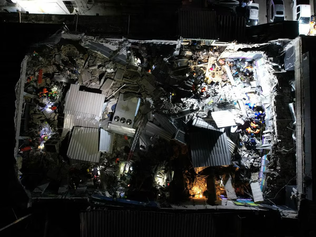 Rescatistas buscan sobrevivientes en edificio colapsado.